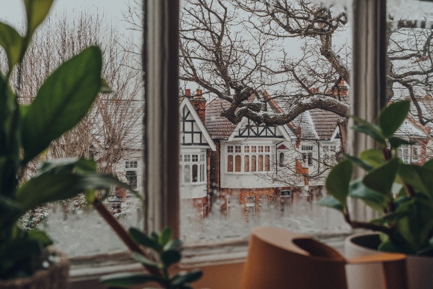 View of the snow through the window from inside the house. Selective focus.