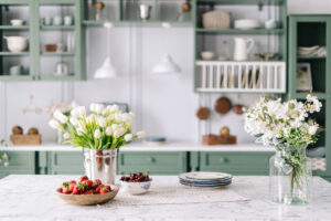 Kitchen countertop with flowers in bucket and jar